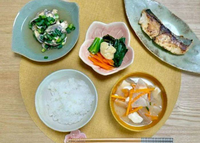 The dishes of a Japanese home cooking class, plated on a series of decorative, colorful dishes.